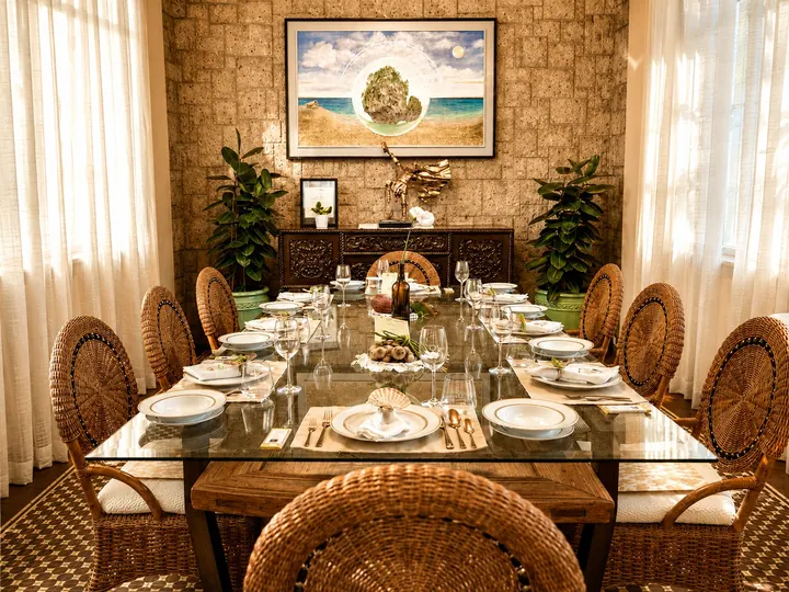 The Melissa Room: a glass-topped table with rattan chairs under a painting, against a stone wall