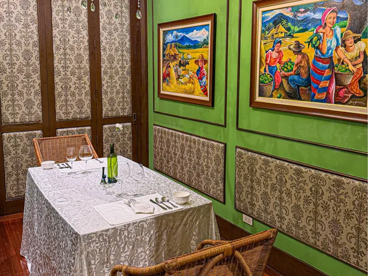 The Proposal Room: a small table in lace linen, green walls hung with Filipino paintings, and a chandelier
