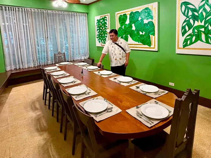 The Zenaida Room: bright green walls, leaf-bladed ceiling fans and a long wooden table set for twelve